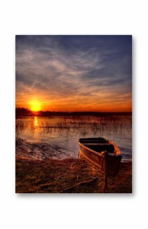 a boat by the lake at sunset