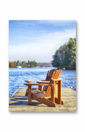 Two Muskoka chairs on a wood dock at a blue lake