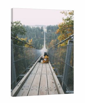 Young woman exploring nature by walking on a long bridge in Germany