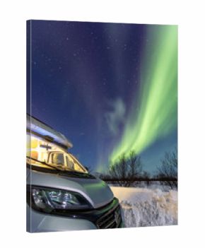 Beautiful northern lights and camper on foreground