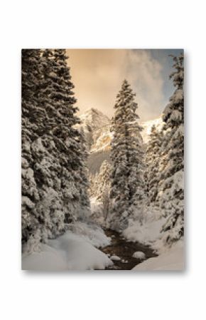 Picturesque view of snowy river in highland terrain on background of sundown sky in evening