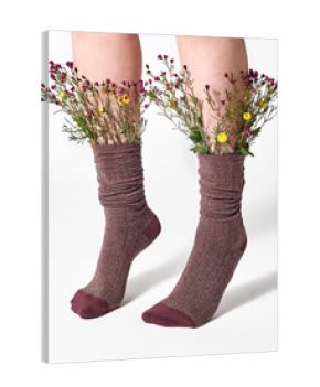 Woman wearing brown socks with wild flowers sticking out.