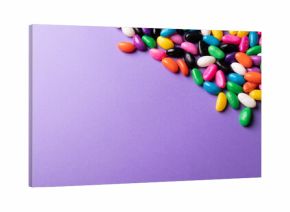 Directly above view of multi colored candies on purple background with copy space