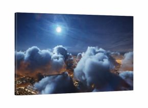 Flying over the deep night timelapse clouds with moon light. Seamlessly looped animation. Flight through moving cloudscape over night city lights. Perfect for cinema, background, digital composition.