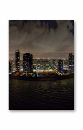 Aerial night drone panoramac photo coastal city highrise tower illuminated