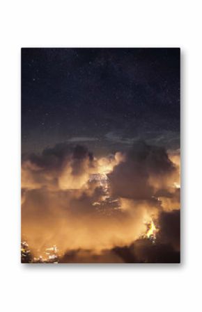Flying over the deep night clouds with dark sky. Flight through moving cloudscape over night city lights. Perfect for posters, background, digital composition.