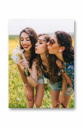 3 beautiful hippie girl in a field of yellow flowers