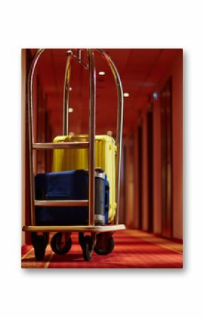 Cart of porter with suitcases in aisle of hotel