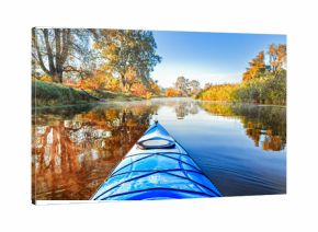 View from the blue kayak on the river banks with autumnal yellow leaves trees in fall season. The Seversky Donets river, autumn kayaking. View over nose of bright yellow kayak.