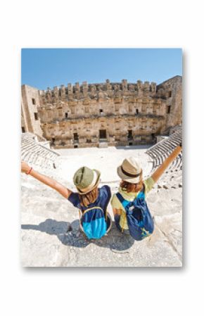 Two young girls student traveler enjoy a tour of the ancient Greek amphitheater