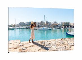 Elegant young tourist visitor woman walking on a sightseeing tour at Heraklion Venetian port, Crete, Greece