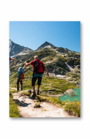 family with child hiking on holiday in austrian alps with lake and glacier view