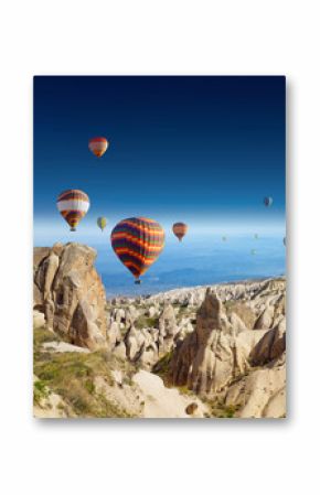 Hot air balloons flies in clear deep blue sky in Cappadocia