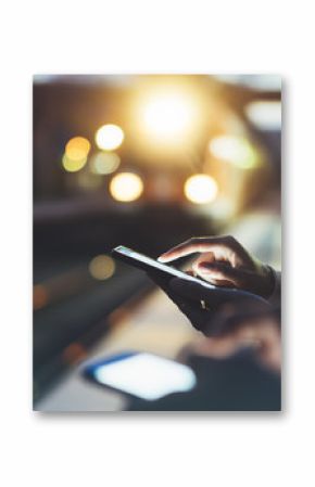 Enjoying travel. woman waiting on station platform on background light electric moving train using smart phone in night. Tourist texting message and plan route of stop railway, railroad transport