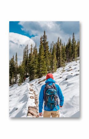 Tourist with backpack hiking on snowy trail