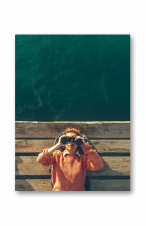 Young Beautiful Girl Lies On A Pier Near The Sea And Looks Through Binoculars On The Sky. Travel Search Journey Concept