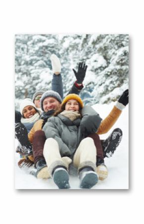 Four funny friends in winterwear riding down hill in snow on winter weekend