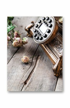 Old vintage black rotary phone and a bouquet of roses