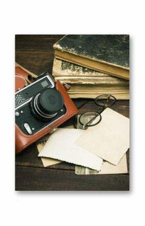 retro still camera and some old photos on wooden table background