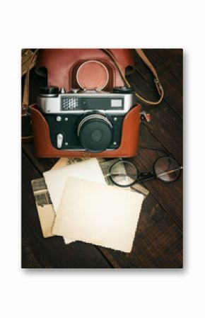 retro still camera and some old photos on wooden table background