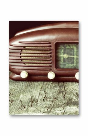 Vintage photo of old radio standing on the old wooden desk. Released in 1953. Black background. All potential trademarks are removed and blurred.