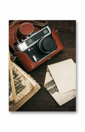 retro still camera and some old photos on wooden table background