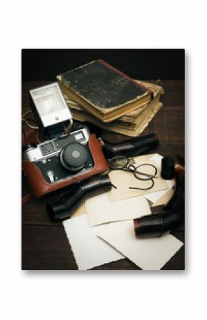 retro still camera and some old photos on wooden table background    