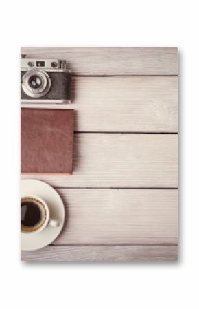 Retro camera, notebook and cup of coffee on wooden desk