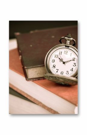 Old vintage books and pocket watches on wooden desk. Retro style filtered photo