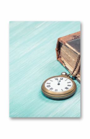 Antique book and old retro brass pocket watches on wooden desk background. Vintage style filtered photo