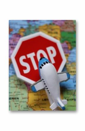 Airplane Traffic Limitations. Air traffic stopped.Air travel prohibited.Ban on air travel.Coronavirus epidemic. Decorative airplane and stop sign on world map background.Flying on a plane Ban