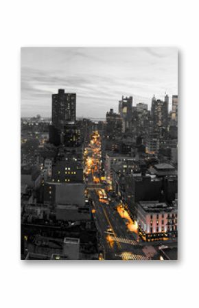 Yellow lights of the New York City skyline shining against a black and white cityscape in Lower Manhattan NYC