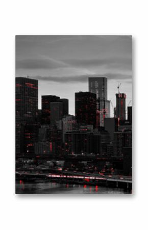 Red lights shining in black and white night time cityscape with the Brooklyn Bridge and buildings of Manhattan in New York City