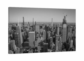 Aerial panoramic black and white view of Manhattan, showcasing countless skyscrapers and the distant horizon. A powerful and urban, yet sober image