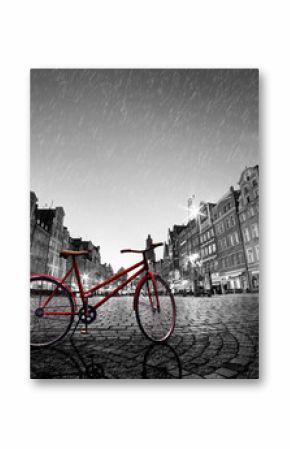 Vintage red bike on cobblestone historic old town in rain. Wroclaw, Poland.