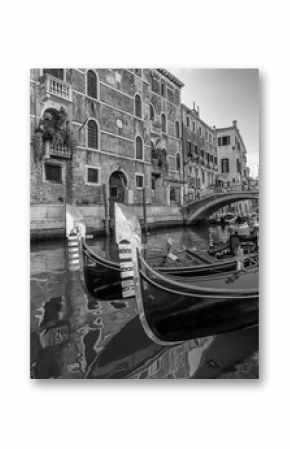 Black and white view of typical traditional gondolas parked in a Venetian canal, Fondamenta dei Preti, Venice, Italy