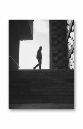 silhouette of a walking man in a city. black and white photo