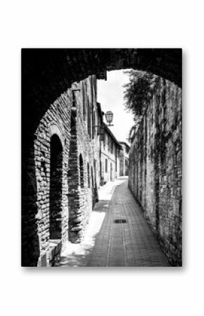Picturesque medieval narrow street of San Gimignano old town, Tuscany, Italy. Black and white image.