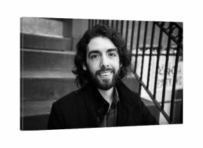 LGBT Chilean Man with beard sits on urban New York City stoop