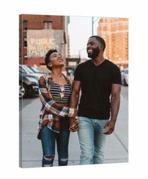 A young black couple walking around the city at sunset