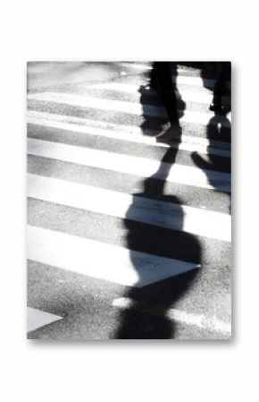 Blurry zebra crossing with pedestrians making long shadows