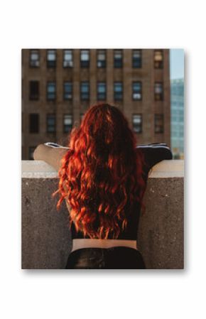 A teenage girl watching the sunset in the city