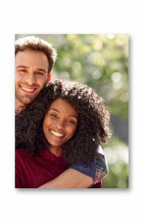 Diverse couple affectionately standing together ouside on a sunny day