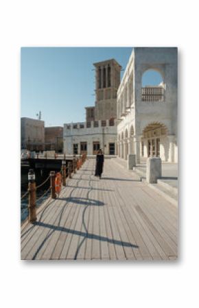 Woman in long black dress in old town of Dubai