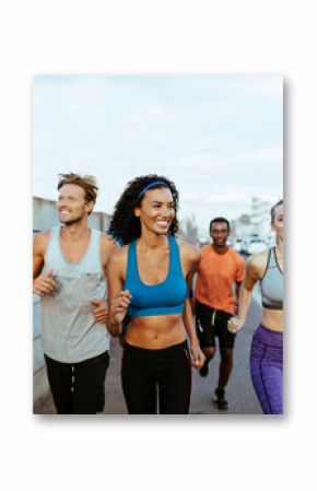 Group of fit friends running together outdoors on city street