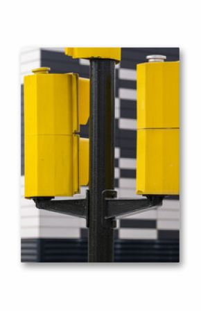 Close-up of yellow traffic lights against black and white striped facade, strong contrast and geometry, ideal for design, architecture and city infrastructure imagery.