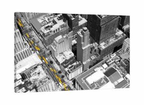 Overhead view of yellow taxis driving through the black and white buildings of Midtown Manhattan in New York City