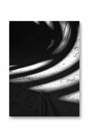 A black and white photo of an empty skateboard ramp