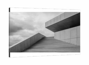 A gray building with a gray roof and gray steps. The building is tall and has a lot of steps