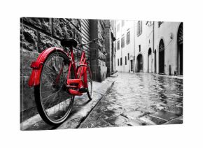 Retro vintage red bike on cobblestone street in the old town. Color in black and white